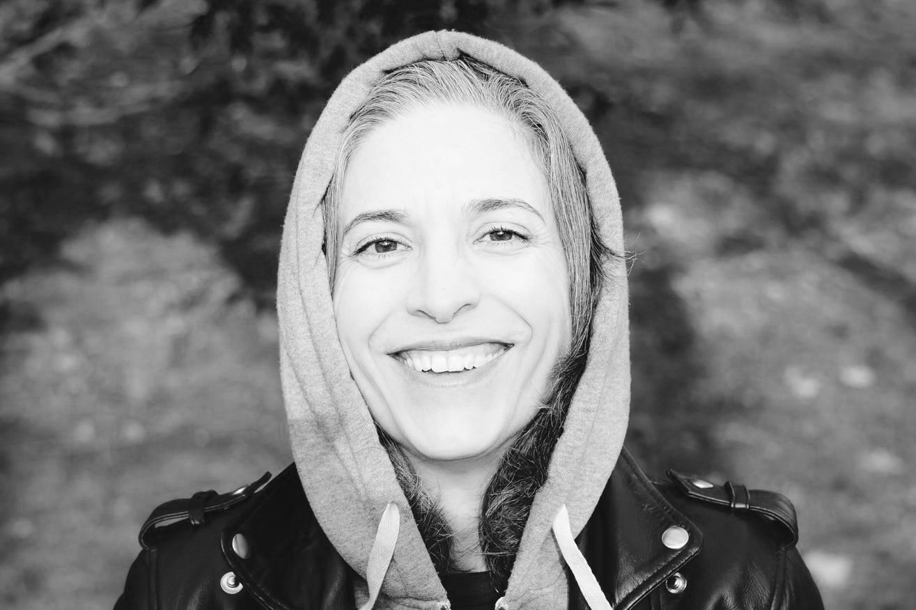 man standing on mountain edge looking at sunset